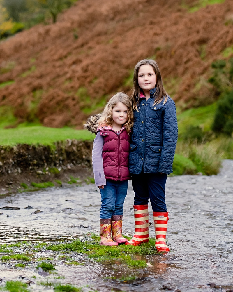sisters standing in stream at Cardingmill Valley Shropshire