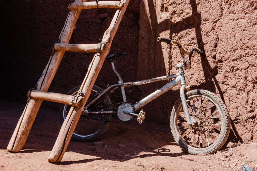 wooden ladder leaning over a childs bike in Morocco taken by travel photographer Victoria La Bouchardiere