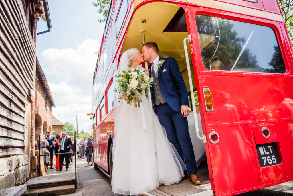 bride and groom kiss on double decker bus at Pimhill Barn wedding venue photographed by Victoria La Bouchardiere
