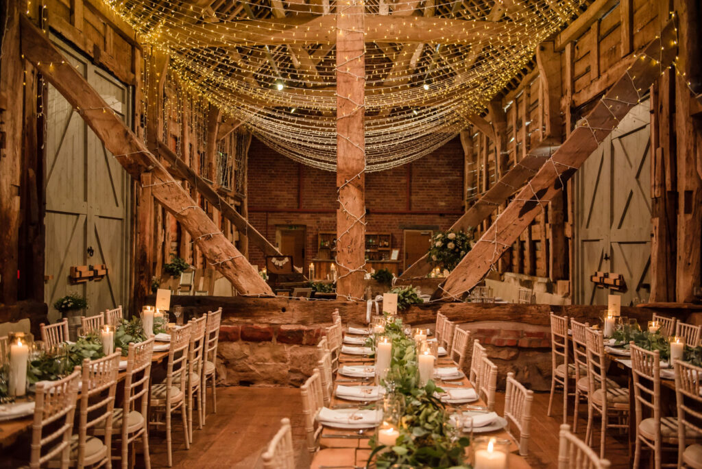 Pimhill barn wedding venue decorated in fairy lights with trestle tables