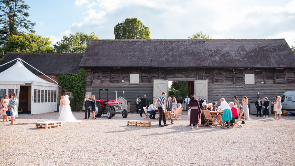 barn wedding venue Pimhill with doors open and wedding guests outdoors